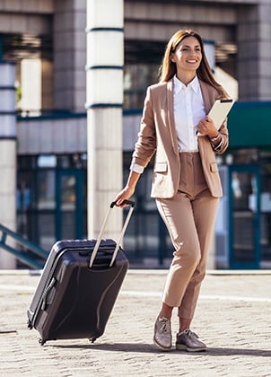 Business woman walking with luggage to the airport.